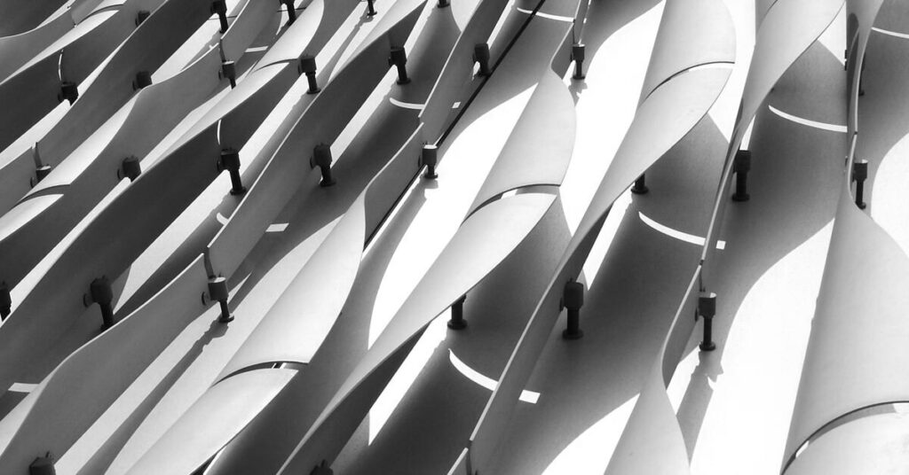 Fanned metal fins on a building exterior in greyscale