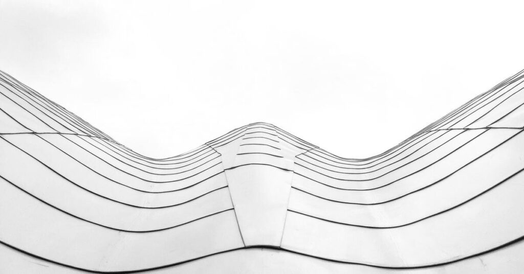 Undulating architectural lines against a pale sky